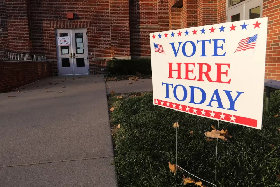"Vote Here Today" yard sign in front of brick building.